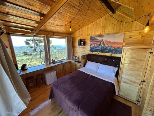 a bedroom with a bed in a wooden room at Pousada e Camping do Motochileiro in Urubici