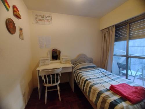 a bedroom with a bed and a desk and a window at Habitación single con baño privado en departamento compartido in Cordoba