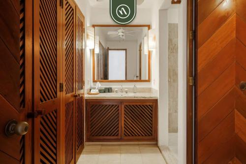 a bathroom with a sink and a mirror at 4 BR Penthouse - Breathtaking Views - Private Pool in Ixtapa