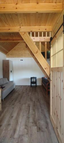 Una habitación con altillo con cama y techos de madera. en Domek Czarnucha, en Augustów