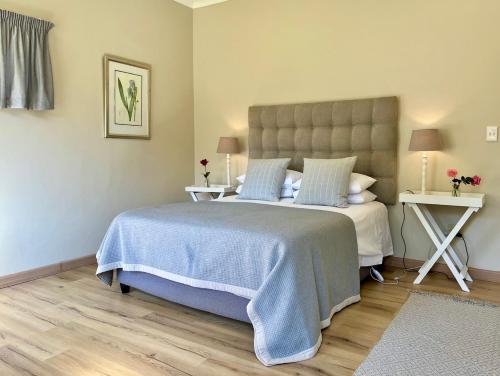 a bedroom with a large bed with a blue blanket at Autumn Way in Clarens