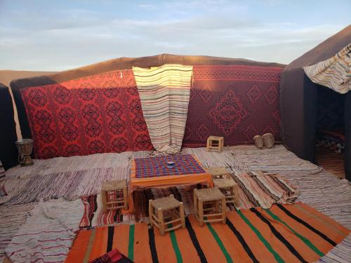 a living room with a table and chairs on a couch at Merzouga Standard Camp in Merzouga