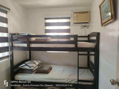 a bedroom with three bunk beds in a room at Serene Home Stay in Puerto Princesa City