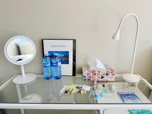 a glass table with two bottles of water and a mirror at Home in Downtown in Toronto