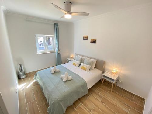 a bedroom with a bed with two towels on it at Casa do Sol in Sagres