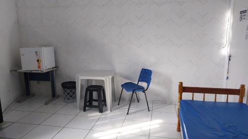 a room with two chairs and a table and a bed at POUSADA PERLLA's Pindamonhangaba in Pindamonhangaba