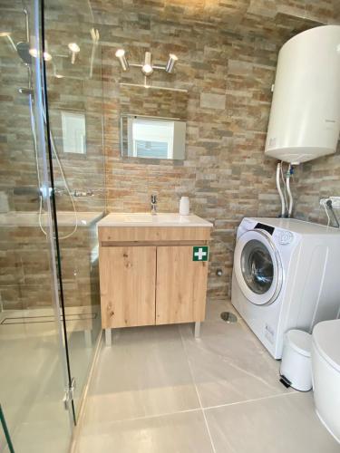 a bathroom with a sink and a washing machine at Casa do Sol in Sagres