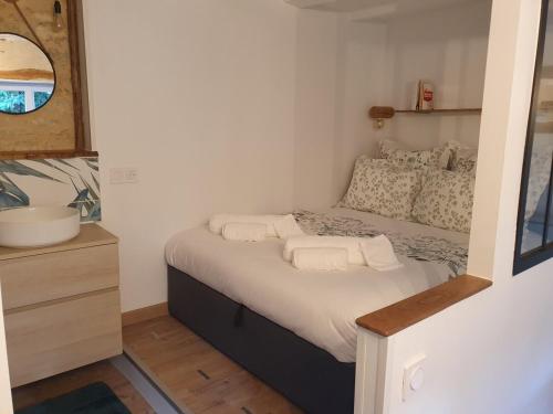 a small bedroom with a bed and a sink at Studio cosy & ses troglos "Chez Evariste" in La Tricherie