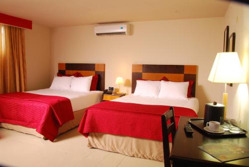 Habitación de hotel con 2 camas, mesa y escritorio en Metro Hotel Panama, en Panamá