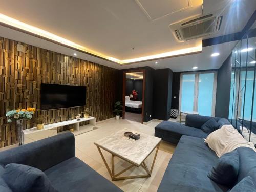 a living room with blue couches and a tv at Luxurious Appartment in GOLDCREST DHA Lahore in Lahore