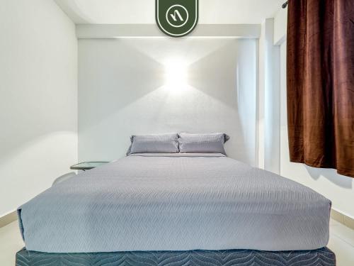 a bed in a room with a clock on the wall at 2BR Condo with Private Terrace - Near to the Beach in Nuevo Vallarta 