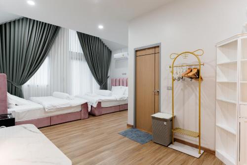 Cette chambre comprend 3 lits et une porte menant à une chambre. dans l'établissement 101 Grand Home Poolvilla, 