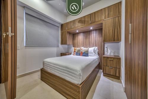 ein kleines Schlafzimmer mit einem Bett in einem Zimmer in der Unterkunft Brand New 1 BR Condo - Pool - Jacuzzi - Gym in Nuevo Nayarit