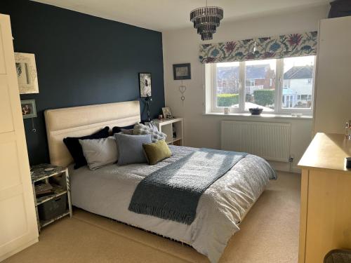 Un dormitorio con una cama grande y dos ventanas. en New Forest home - 4-beds and garden - 10 mins from Beach, en Hordle