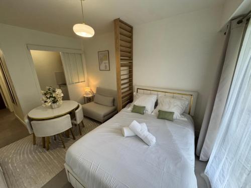 Un dormitorio con una cama y una mesa con una silla. en Studio moderne et sécurisé, en Compiègne