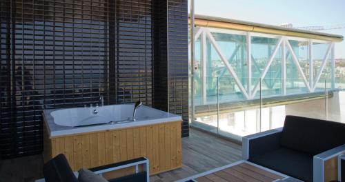 a bath tub in a room with a large window at Hugo's Boutique Hotel - Adults Only in St Julian's