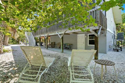 two chairs and a table in front of a building at Your Island Oasis Awaits on Sanibel - Near Beach in James Cipriani Heliport