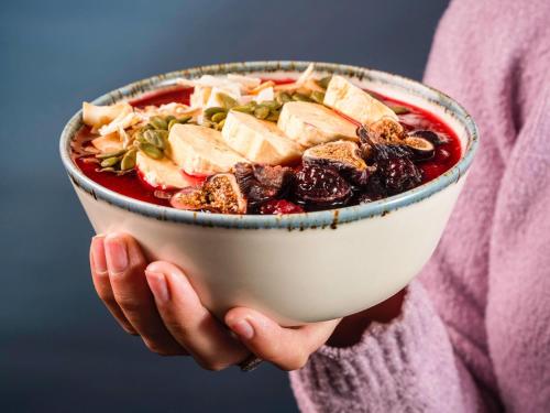 Una persona sostiene un tazón de comida. en Pullman Santiago El Bosque, en Santiago