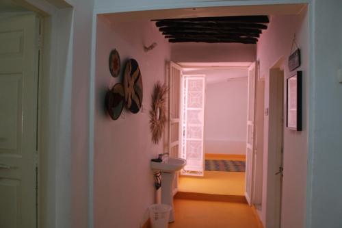 pasillo con habitación con aseo y ventana en NOMAD Hostel Stone Town, en Zanzíbar