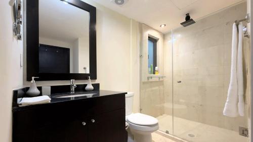 a bathroom with a toilet and a shower with a mirror at Big & Luxury 2BR on 5th Ave, King Bed, 2 Baths in Playa del Carmen
