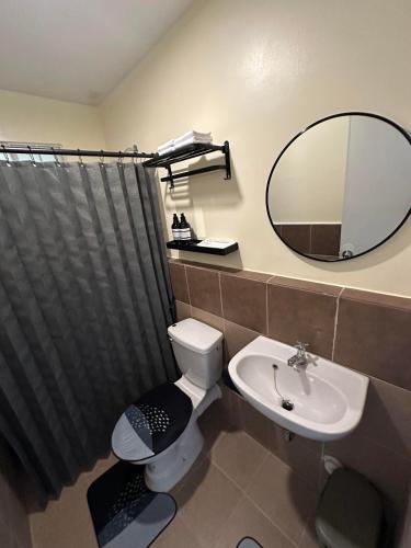 a bathroom with a toilet and a sink and a mirror at D'living Condotel in Davao City