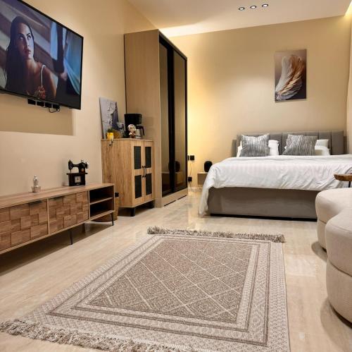 Un dormitorio con una cama y un televisor de pantalla plana. en استديو انيق بحي السليمانيه, en Riad