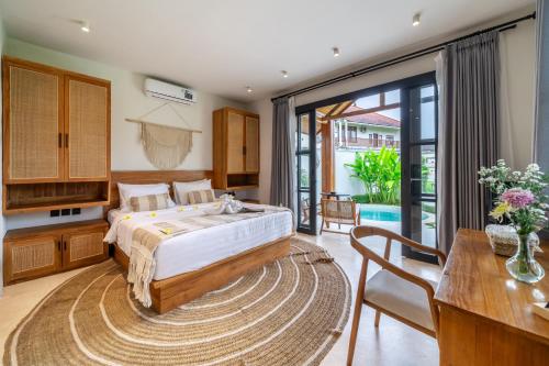 Un dormitorio con una cama grande y una mesa. en Tranquil Living at Sarang Apartments 4 in Ubud, en Ubud