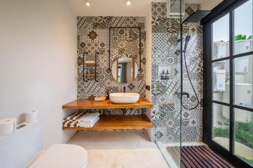 un baño con lavabo y espejo en Tranquil Living at Sarang Apartments 4 in Ubud, en Ubud