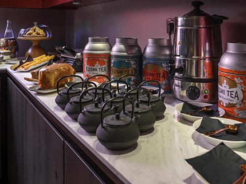 a counter top with a bunch of jars of food at Novotel Saint-Étienne Centre Gare Châteaucreux in Saint-Étienne