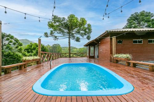 ein Swimmingpool auf einer Terrasse mit einem Haus in der Unterkunft Altos das Araucárias - one place, great moments! in Alfredo Wagner
