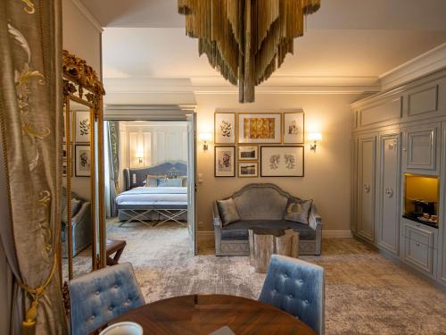 a living room with a table and a bedroom at Bachleda Luxury Hotel Kraków - MGallery Collection in Kraków