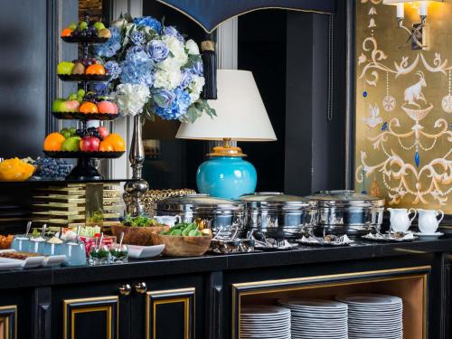 a buffet with plates and food on a table at Bachleda Luxury Hotel Kraków - MGallery Collection in Kraków