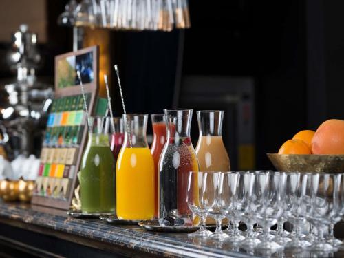 a table topped with glasses and bottles of juice at Bachleda Luxury Hotel Kraków - MGallery Collection in Kraków