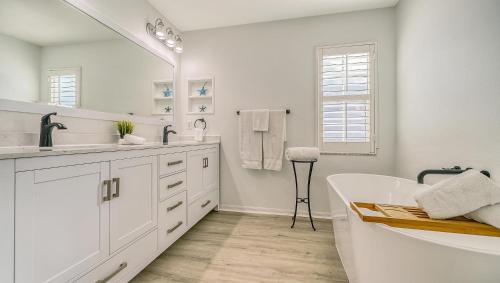 a white bathroom with a tub and a large mirror at Island Escape - 638 in Siesta Key