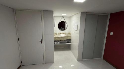 een witte badkamer met een wastafel en een spiegel bij Loft Firenze - Conforto e Estilo na Serra Gaúcha in Bento Gonçalves