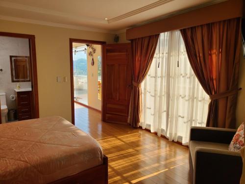 クエンカにあるHilltopBellavista Suite Oneのベッドとガラスの引き戸のある寝室