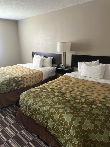 a hotel room with two beds and a lamp at Rodeway Inn in Webster