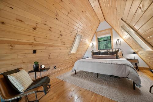Un dormitorio con una cama y un techo de madera. en Alpine A-Frame at Calm Ridge Treehouses, en Boone