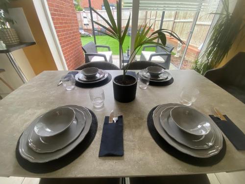 a table with black plates and napkins on it at Manor Park View in Norwich