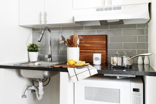 a kitchen counter with a sink and a stove at Intown Suites Extended Stay Select Charlotte NC - University in Charlotte