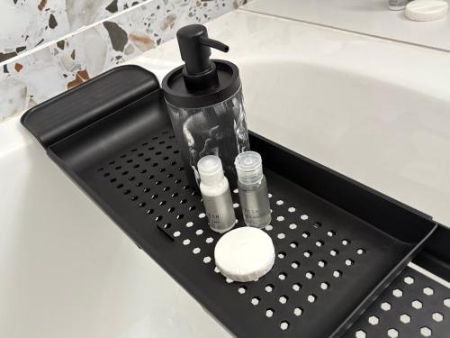 a black tray with two bottles and a sink at Windermere Sands in Gqeberha