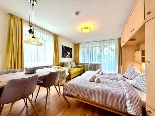 a living room with two beds and a dining room at Alpgold C1 oder Alpherz A8 Montana Haus in Oberstdorf