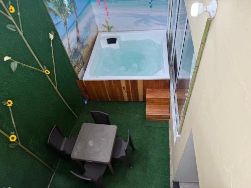 Habitación con bañera, mesa y sillas. en FULL HOUSE CON JACUZZI y ZONA BBQ, en El Colegio