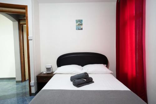 a bedroom with a bed with a red curtain at Seaview Apartment by Beach in Flic-en-Flac