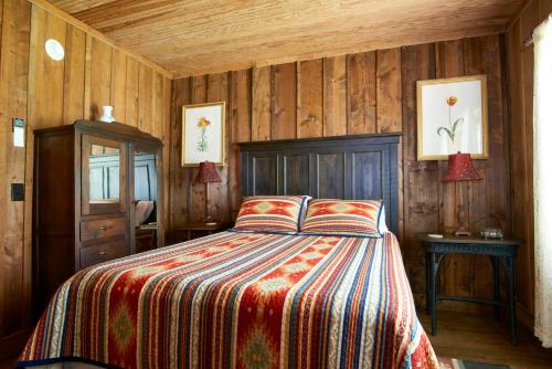 a bedroom with a bed with a colorful blanket at Glen Choga Lodge in Topton