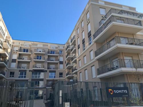 an apartment building with a fence in front of it at DOMITYS - Les Canotiers in Argenteuil