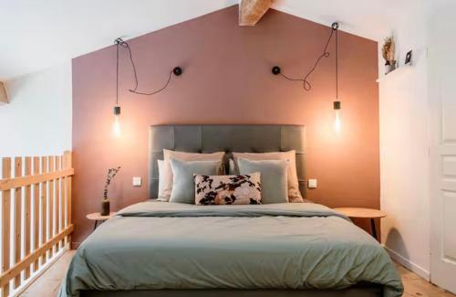 - une chambre avec un grand lit et un mur pourpre dans l'établissement Gîte avec piscine - La Sacristie, à Graulhet