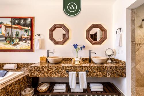 a bathroom with two sinks and two mirrors at 2BR Condo with Private Terrace - Ocean View - Pool in El Tule