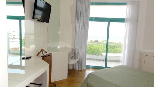 a bedroom with a bed and a tv and a window at Hotel Excelsior in Vasto
