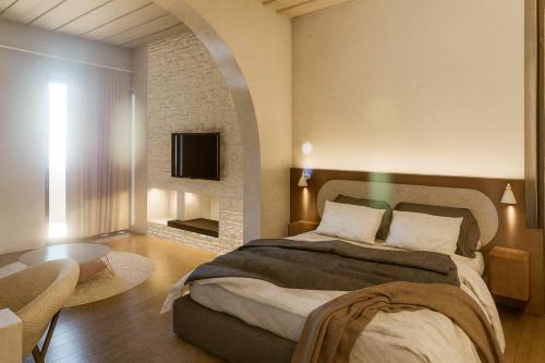 a bedroom with a large bed and a tv at Tholaria Boutique Hotel in Astypalaia Town